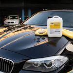 Канистра с полимерным автовоском TED Professional на блестящем капоте черного автомобиля в студии деталинга, демонстрирующая, как наносить жидкий воск Liquid Wax для получения зеркального эффекта.